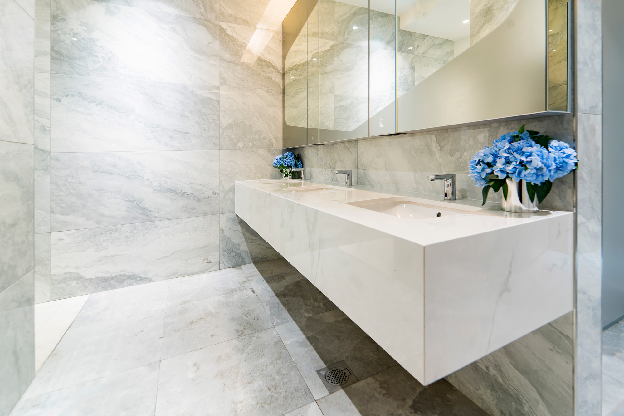 Image of bathroom cape royal 5 in Dekton adds a new touch of elegance to the reception area of a luxury development in Singapore - Cosentino
